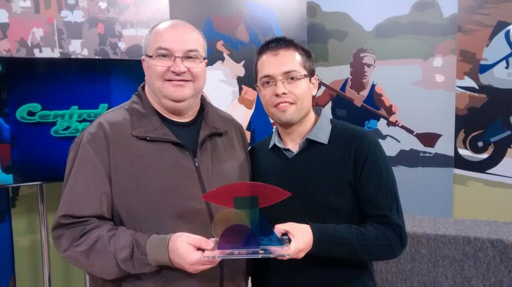 Tiago (d), com o troféu do Expocom e o orientador, prof. Gilson Piber. Foto Márcio Santos
